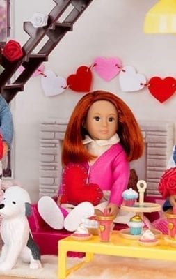 Three dolls making heart crafts.